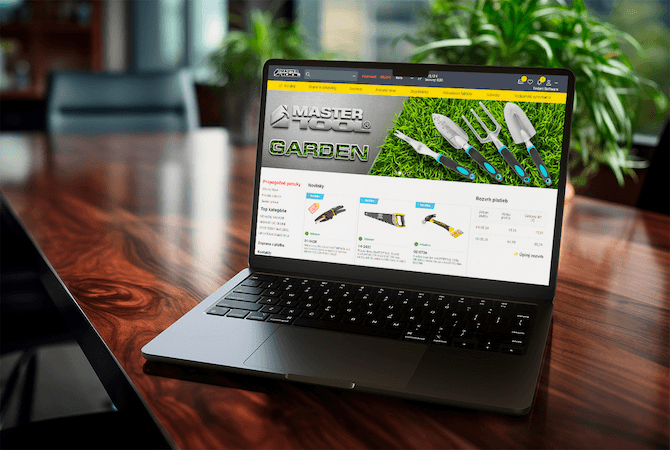 A laptop on a desk showing the Mastertool garden tools catalogue, with category filters, product cards and prices on screen.